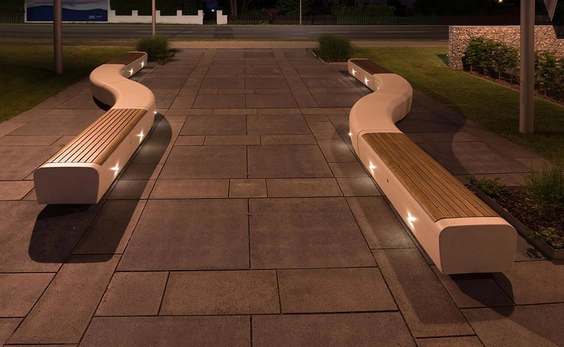Bancas curvas con iluminación integrada en plaza urbana